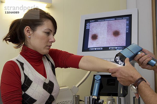 Hautarzt  Dermatologe untersucht Patientin mittels Videodermatoskopie  Deutschland  Europa