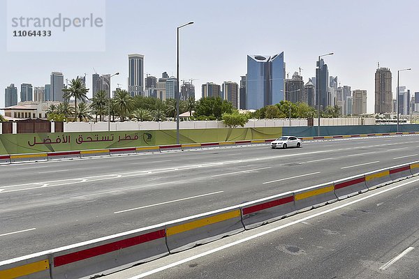 Auto auf einer fünfspurigen Strasse vor der Skyline von Doha  Katar  Asien