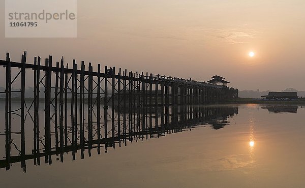 Sonnenaufgang über der U-Bein-Brücke  die den Taungthaman-See überquert  die längste Teakholz-Fußgängerbrücke der Welt  Amarapura bei Mandalay  Myanmar  Asien
