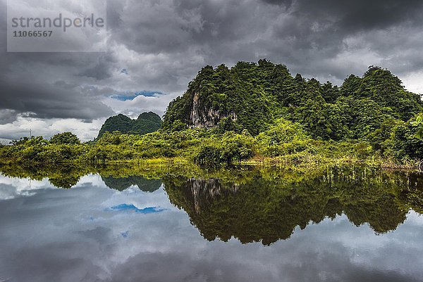 Turmkarstberge mit dunklen Wolken  Blick auf die Landschaft  Spiegelung im Wasser  Hpa-an Umgebung  Karen oder Kayin Staat  Myanmar  Burma  Birma  Asien