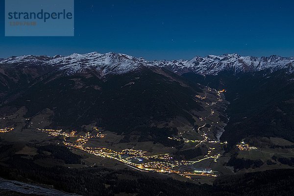 Nächtlich beleuchtete Täler  hinten die Zillertaler Alpen  vorne Matrei im Wipptal  hinten Navistal  Tirol  Österreich  Europa