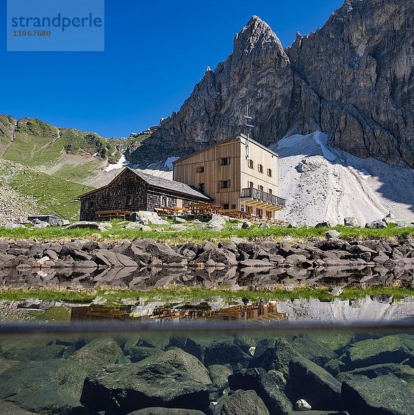 Südtiroler Tribulaunhütte mit See  Splittingaufnahme  vorne See Unterwasseransicht  hinten Berg Goldkappl mit Sandesjöchl  Pflerscher Scharte  Pflerschertal  Südtirol  Bozen  Italien  Europa