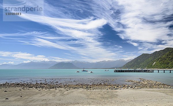 Fischerboot vor Bootssteeg und türkisem Meer  Wolkenhimmel  Jackson Bay  Westcoast  Tasmansee  Südinsel Neuseeland