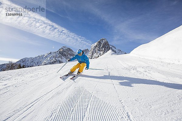Skifahrer mit Helm fährt die Skipiste runter  Mutterer Alm bei Innsbruck  Tirol  Österreich  Europa