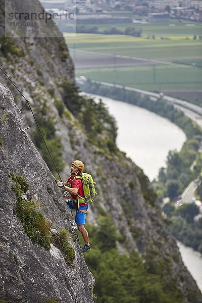 Bergsteiger  Kletterer mit orangen Helm beim Aufstieg am Klettersteig  Zirl  Innsbruck  Tirol  Österreich  Europa