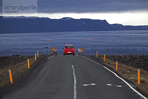 Rotes Auto fährt auf der Ringstraße 1  Route 1  hinten der Gletscher Skeidararjökull  Südisland  Island  Europa