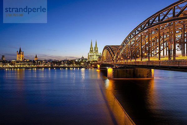 Kirche Groß Sankt Martin und Kölner Dom mit Hohenzollernbrücke über den Rhein  Abenddämmerung  Köln  Nordrhein-Westfalen  Deutschland  Europa