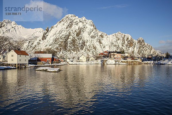 Wohnhäuser an der Hafeneinfahrt von Svolvær vor schneebedeckten Bergen  Svolvaer  Austvågøya  Lofoten  Nordland  Norwegen  Europa