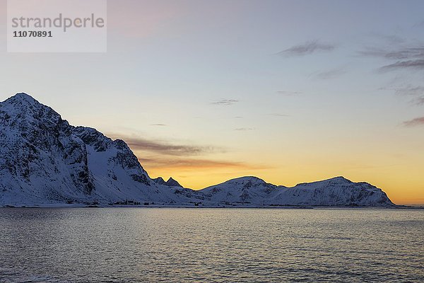 Verschneite Küstenlandschaft bei Sonnenuntergang  Flakstad  Flakstadøy  Lofoten  Nordland  Norwegen  Europa