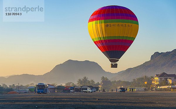 Bunter Heißluftballon in der Luft vor der Landung  hinten Karstberge  Vang Vieng  Vientiane  Laos  Asien