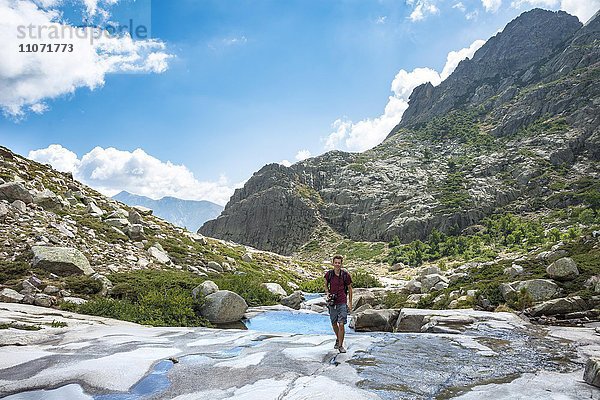 Junger Mann wandert am Fluss Golo im Gebirge  Regionaler Naturpark Korsika  Parc naturel régional de Corse  Korsika  Frankreich  Europa