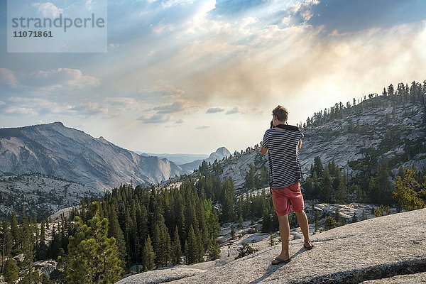 Junger Mann  Tourist fotografiert  Ausblick in die High Sierra  Olmsted Point  Yosemite Nationalpark  Kalifornien  USA  Nordamerika