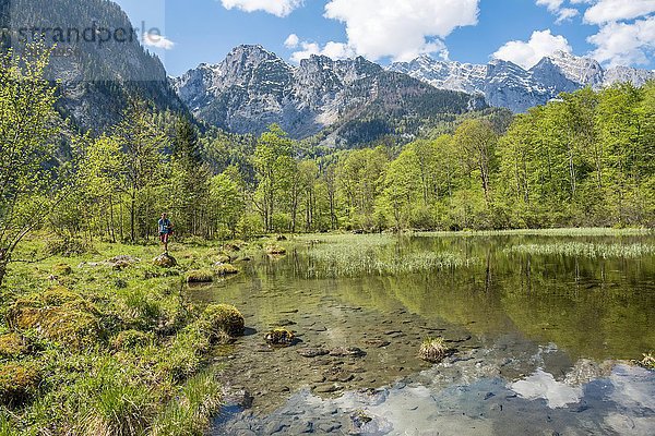 Junger Mann am See  Berge spiegeln sich im Mittersee  Salet am Königssee  Nationalpark Berchtesgaden  Berchtesgadener Land  Oberbayern  Bayern  Deutschland  Europa