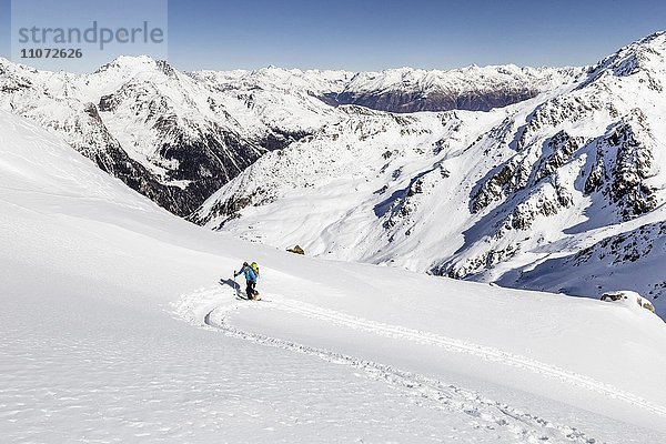 Skitourengeher beim Aufstieg auf die Hintere Nonnenspitze  unten das Martelltal  im Hintergrund der Vinschgau und der Alpenhauptkamm  Martell  Vinschgau  Südtirol  Trentino-Südtirol  Italien  Europa