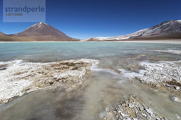 Laguna verde mit Ablagerungen von Borax am Ufer und Schnee auf den Bergen  bei Uyuni  Altiplano  Grenze Bolivien  Chile  Südamerika