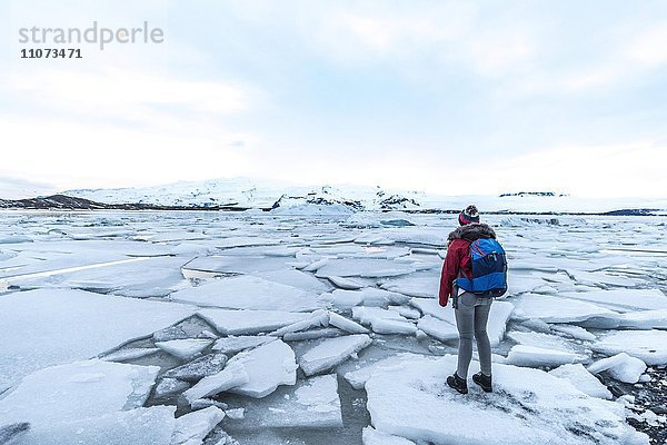 Frau steht auf Eisscholle  Gletscher Lagune Jökulsárlón  Gletschersee  Südrand des Vatnajökull  Südostisland  Island  Europa