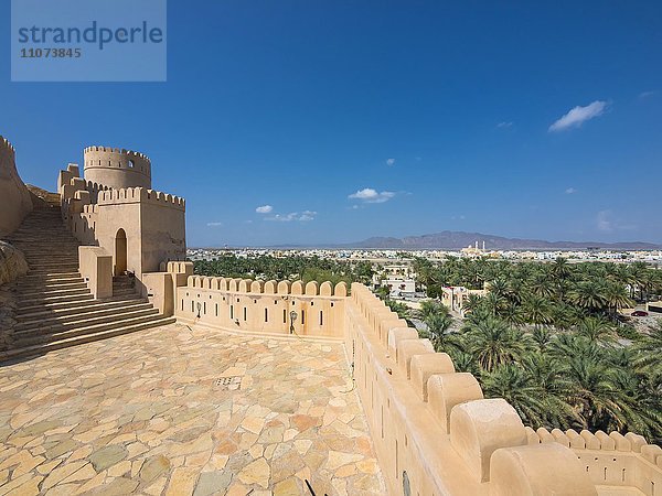 Fort Nakhl  oder Husn Al Heem  Festung  über Oase Nakhl auf Jebel Nakhl Massiv  historischer Lehmbau  hinten Nachl mit der großen Moschee  Provinz Al-Batinah  Sultanat Oman  Golfstaat  Arabische Halbinsel  Naher Osten  Asien