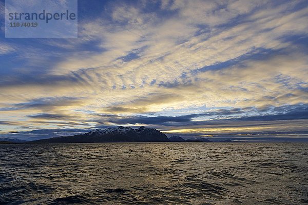 Landschaft  Atlantik mit Bergen und stimmungsvollem Wolkenhimmel bei Tromvik  Norwegen  Europa