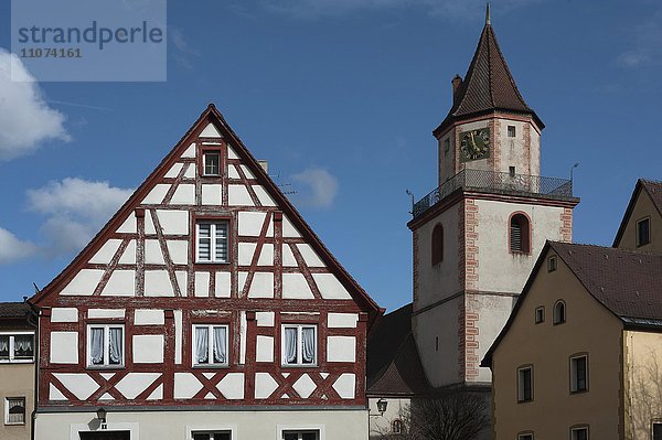 Romanischer Turm der Heiligen Dreifaltigkeits Kirche  links ein altes  fränkisches Fachwerkhaus  Gräfenberg  Oberfranken  Bayern  Deutschland  Europa