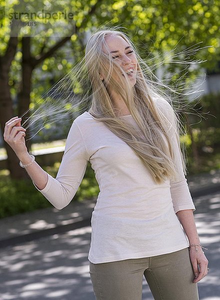 18-jährige junge Frau mit wehenden blonden langen Haaren