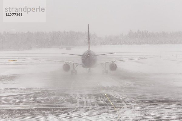 Flugzeug im Unwetter  Schneesturm auf verschneiter Landebahn  Flugplatz Gardermoen  Oslo  Norwegen  Europa