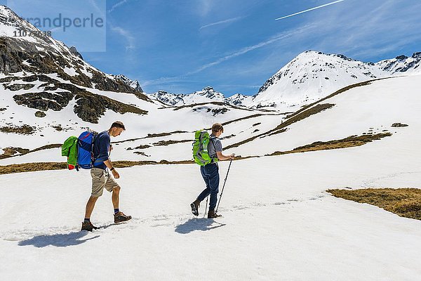 Zwei Wanderer wandern über Schneefeld  Rohrmoos-Untertal  Schladminger Tauern  Schladming  Steiermark  Österreich  Europa