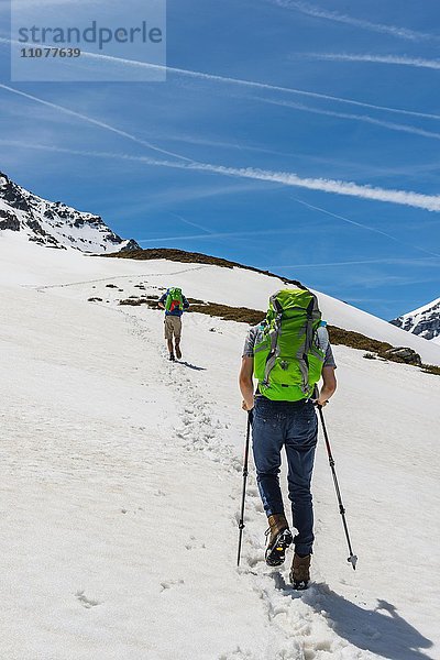 Zwei Wanderer wandern über Schneefeld  Rohrmoos-Untertal  Schladminger Tauern  Schladming  Steiermark  Österreich  Europa