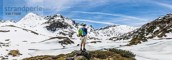 Wanderer steht vor Berglandschaft  Schneereste  Rohrmoos-Untertal  Schladminger Tauern  Schladming  Steiermark  Österreich  Europa