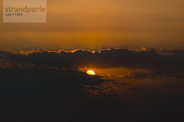 Sonnenuntergang  Sonne scheint durch dunkle Wolken  Mandalay Region  Myanmar  Asien