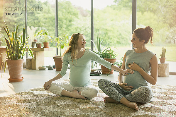 Schwangere Frauen  die den Magen berühren  im Yogakurs