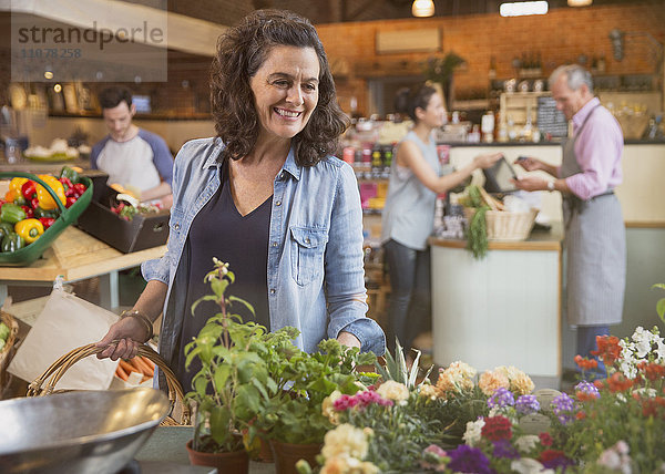 Lächelnde Frau beim Blumenkauf auf dem Markt