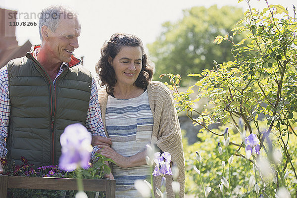 Lächelndes Paar beim Einkaufen von Blumen im Baumschulgarten