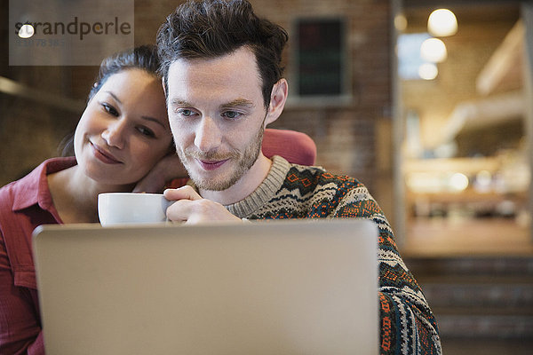 Paar Kaffee trinken und Laptop im Cafe benutzen