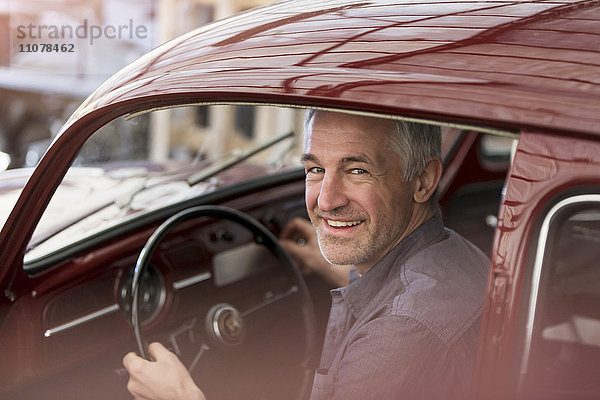 Portrait lächelnder Mechaniker im Oldtimer