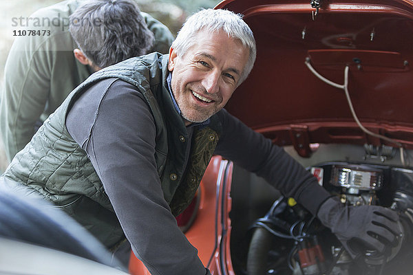 Portrait lächelnder Mechaniker in der Kfz-Werkstatt