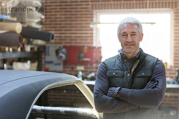 Portrait selbstbewusster Mechaniker in der Kfz-Werkstatt