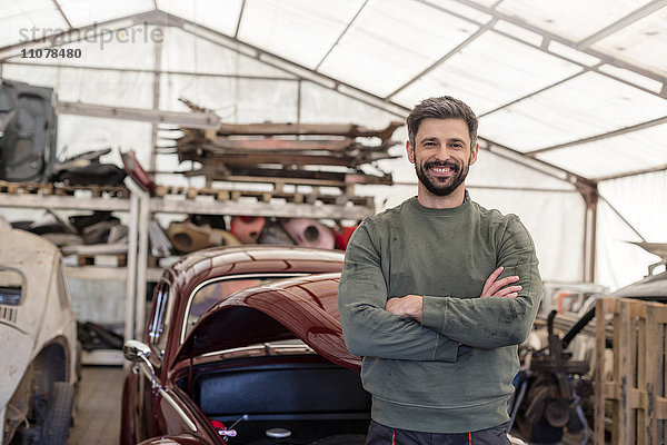 Portrait selbstbewusster Mechaniker in der Kfz-Werkstatt