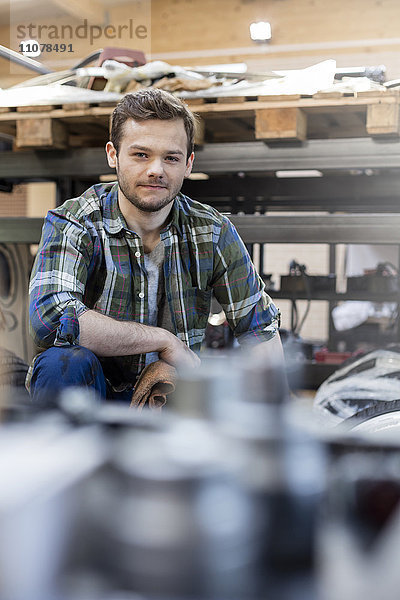 Portrait selbstbewusster Mechaniker in der Kfz-Werkstatt