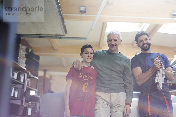 Portrait lächelnde Familienmechaniker in der Autowerkstatt