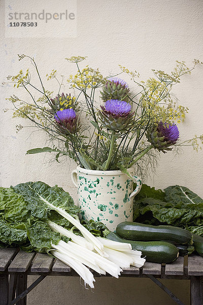Kräuter und Blumen in einer Vase mit verschiedenen Gemüsesorten