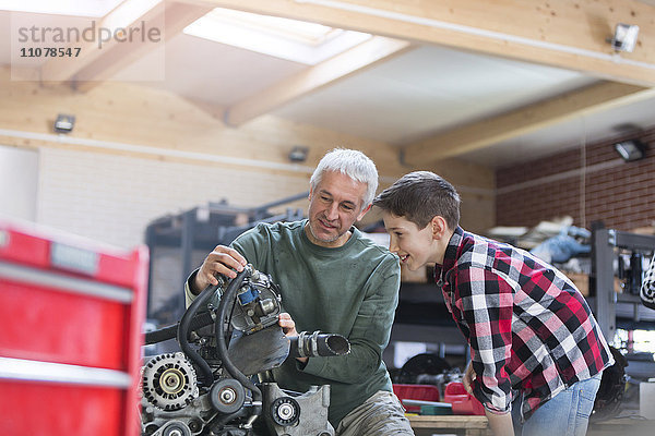 Vater und Sohn beim Motorumbau in der Kfz-Werkstatt