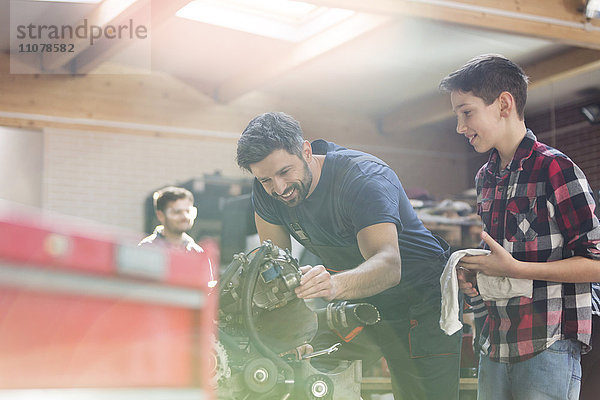 Vater und Sohn bauen den Motor in der Autowerkstatt um