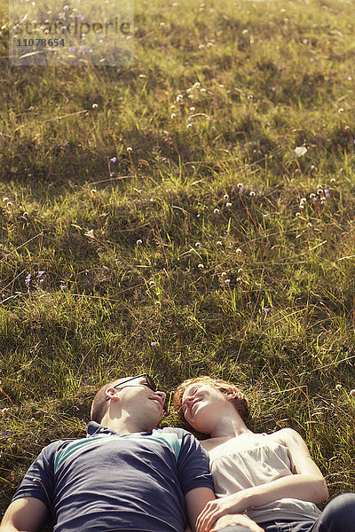 Junges Paar im Gras liegend