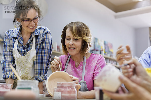 Reife Frau beim Töpfern im Atelier