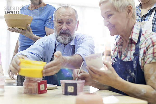 Seniorenpaar malt Keramik im Atelier