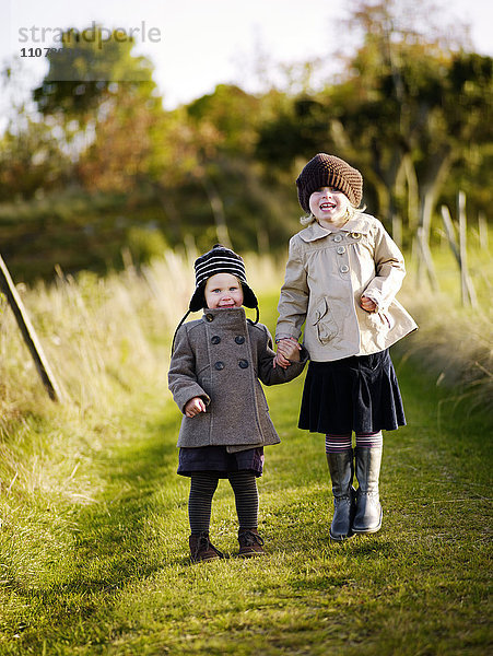 Mädchen gehen im Herbst auf einem Feld spazieren