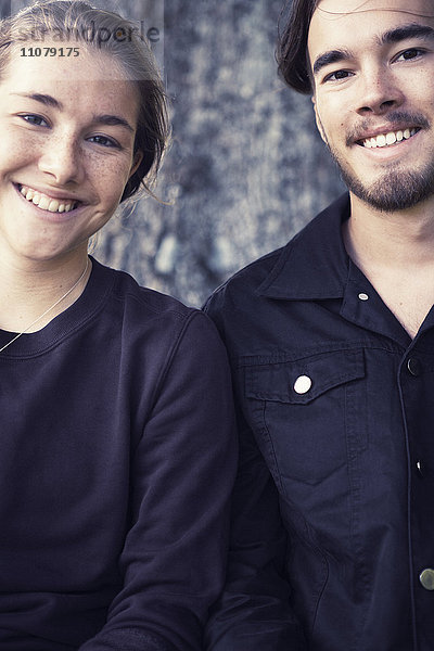 Porträt eines jungen Paares  das Seite an Seite lächelt