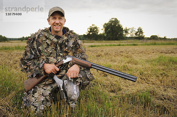 Jäger mit Taube und Gewehr  lächelnd  Porträt