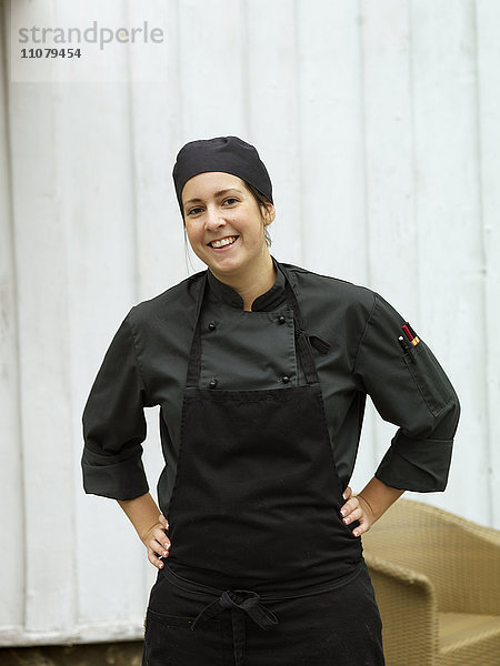 Porträt einer lächelnden Frau in Kochkleidung
