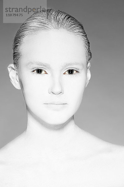 Porträt einer jungen Frau mit weiß bemaltem Gesicht  Studioaufnahme